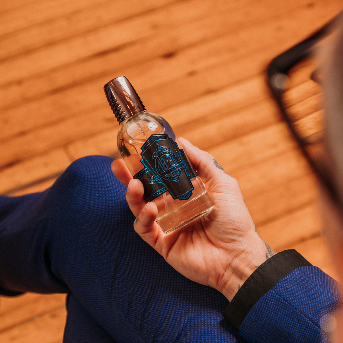 Luxury men's fragrance bottle in hand highlighting a signature scent for men by 18.21 Man Made