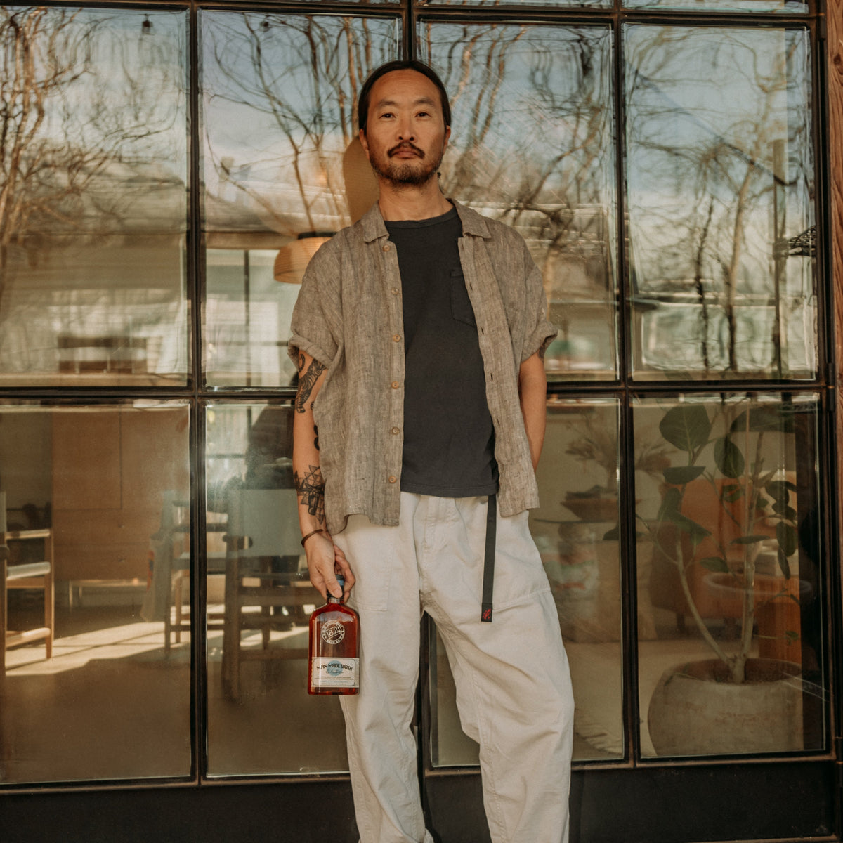 Man standing in front of a large glass door with 18.21 Man Made Wash iin a modern interior setting