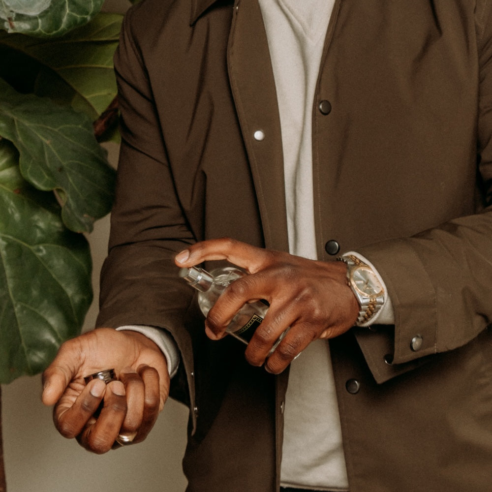 Guy spraying 18.21 cologne on his wrist