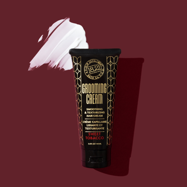 Tube of 1821 Grooming Cream with a swatch of cream on a maroon background