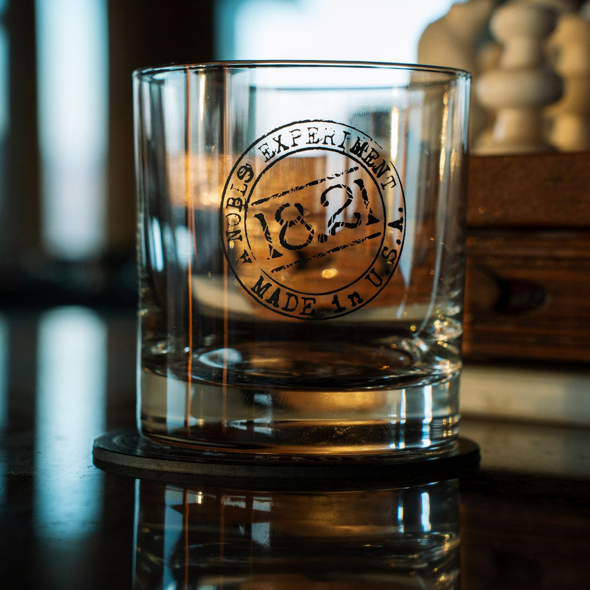 Clear whiskey rocks glass with a 18.21 Man Made logo 