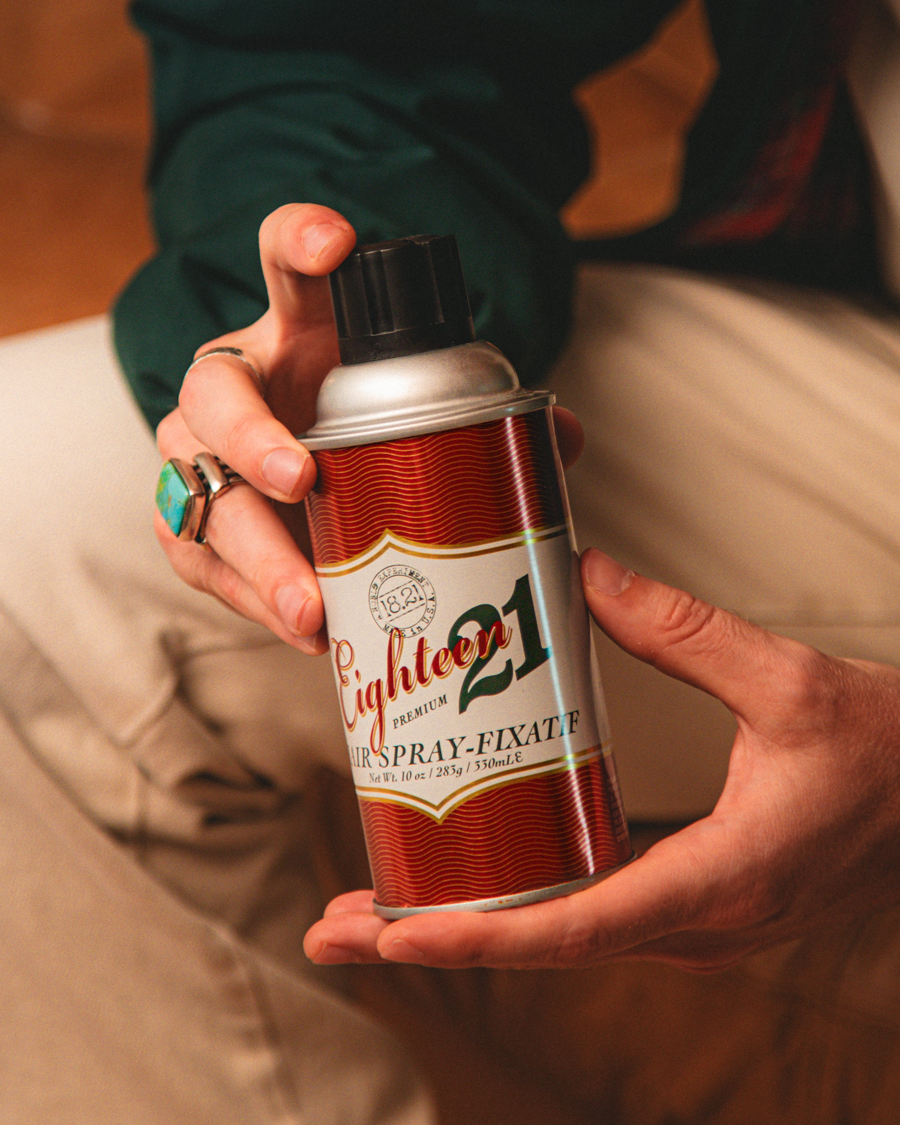 Guy holding 18.21 Man Made hair spray in his hands