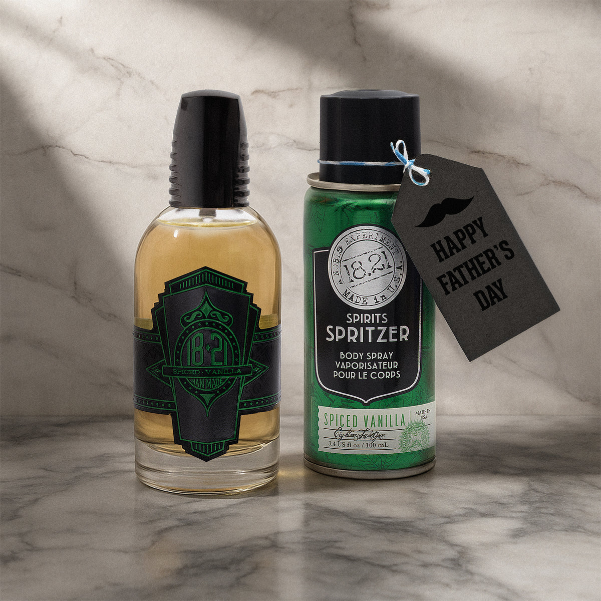 Bottle of body spray and cologne on a marble surface with a 'Happy Father's Day' tag.