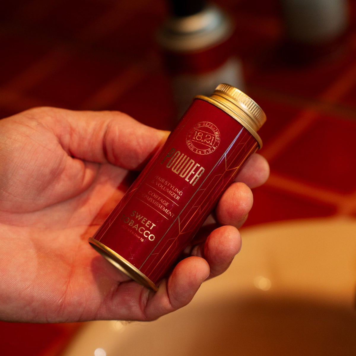 hair powder in hand in bathroom with hairspray in background